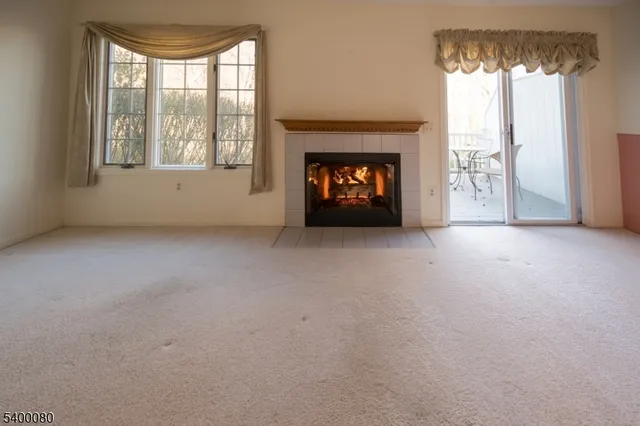 an empty room with a fireplace and windows