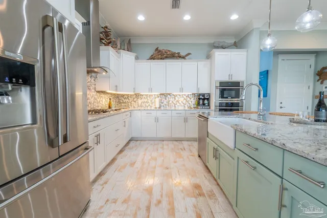 a large kitchen with stainless steel appliances a refrigerator sink and microwave