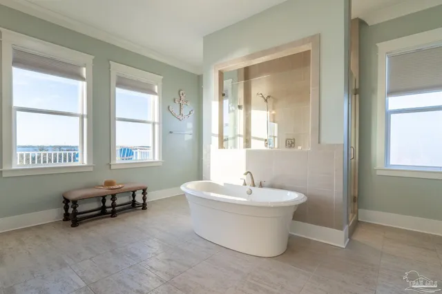 a spacious bathroom with a white tub sitting next to a window