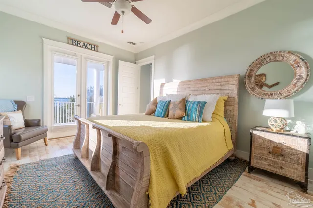 a bedroom with a bed a mirror on dresser and a large window
