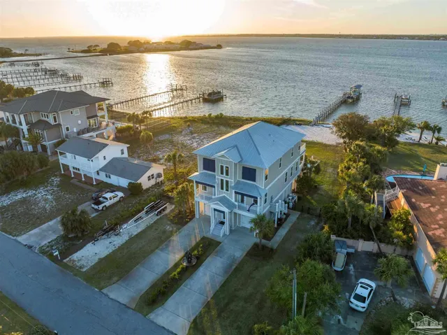 an aerial view of residential houses with outdoor space and ocean view