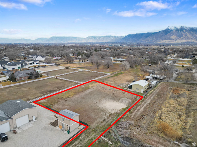 13567 South Redwood Road Riverton, UT 84065 - Photo 4 of 6 Aerial view of residential area with property parcel outlined and a mountain backdrop