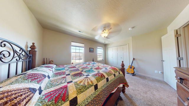 1674 Eastridge Road Price, UT 84501 - Photo 17 of 34 Carpeted bedroom featuring two windows, a ceiling fan with integrated lighting, and a closet with bi-fold doors