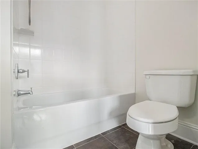 a white toilet sitting next to a bath tub