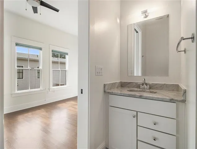 a bathroom with a granite countertop sink and a mirror
