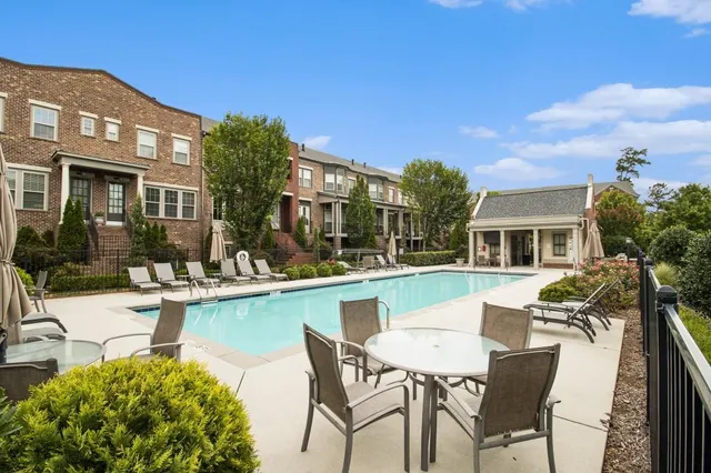a view of a patio with couches table and chairs under an umbrella