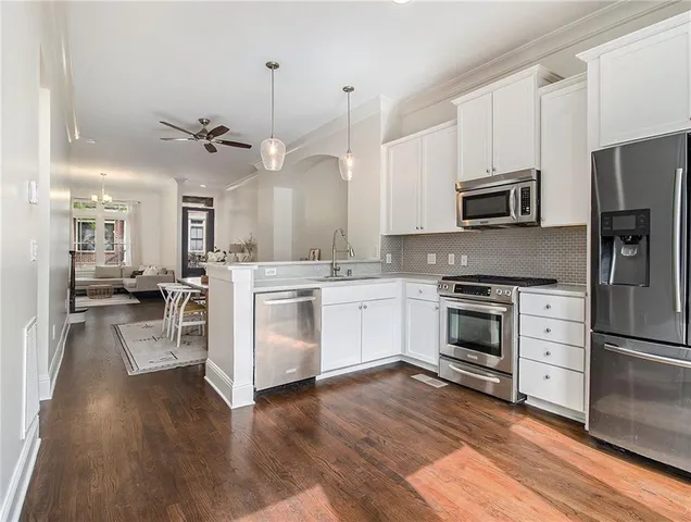 a kitchen with white cabinets and stainless steel appliances