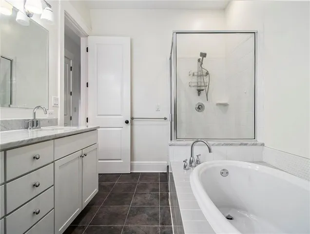 a spacious bathroom with a tub sink and mirror