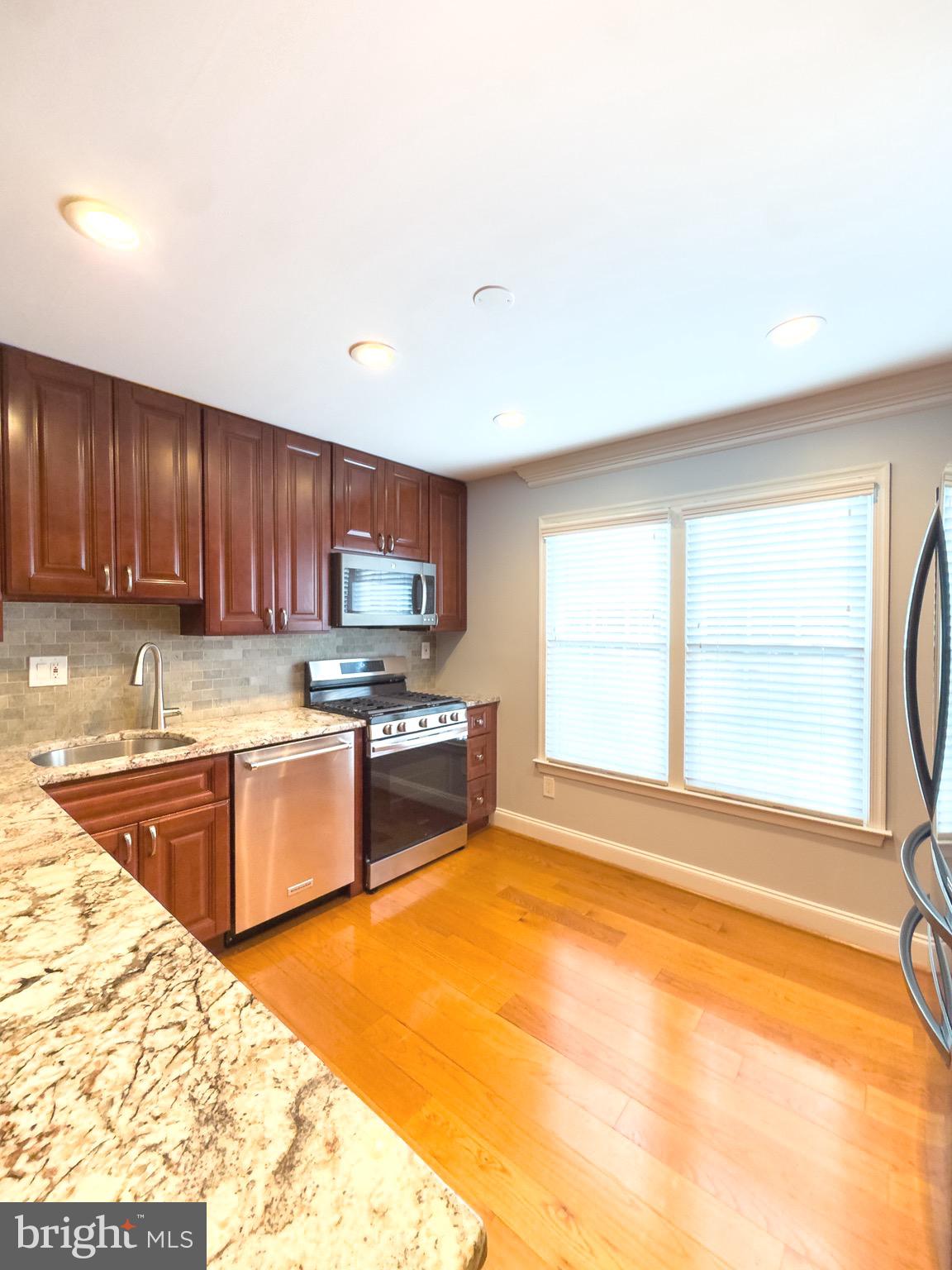 2419 Ansdel Court Reston, VA 20191 - Photo 15 of 41 a kitchen with stainless steel appliances granite countertop a sink stove and cabinets