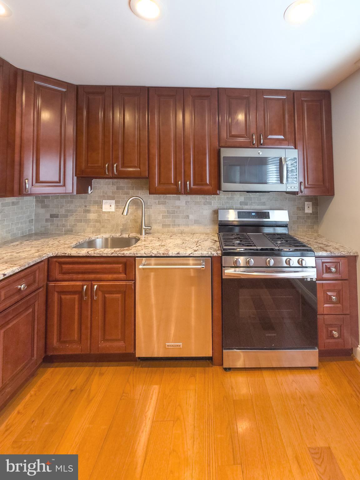 2419 Ansdel Court Reston, VA 20191 - Photo 17 of 41 a kitchen with granite countertop a stove top oven sink and cabinets
