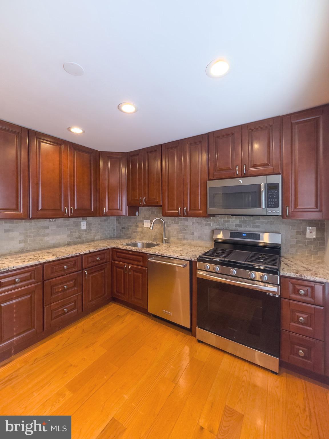 2419 Ansdel Court Reston, VA 20191 - Photo 20 of 41 a kitchen with wooden cabinets stainless steel appliances and a sink