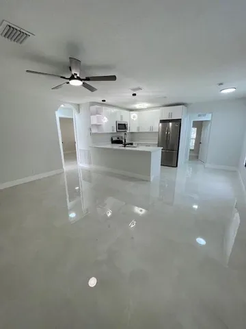 a view of a kitchen with a sink and a ceiling fan