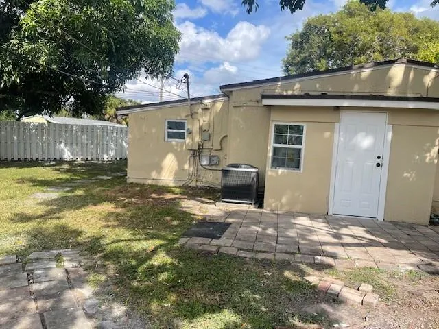 a front view of house with yard and trees in the background