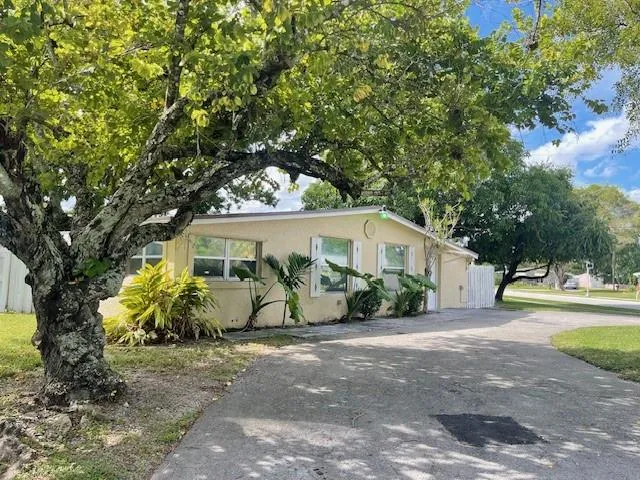 a view of a house with garden and a trees