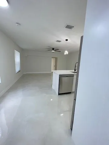 a kitchen with stainless steel appliances a refrigerator a sink a stove and white cabinets