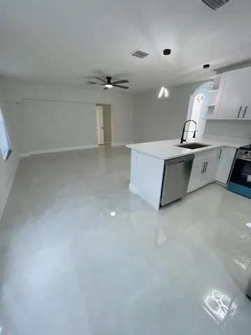 an empty room with a ceiling fan and wooden floor