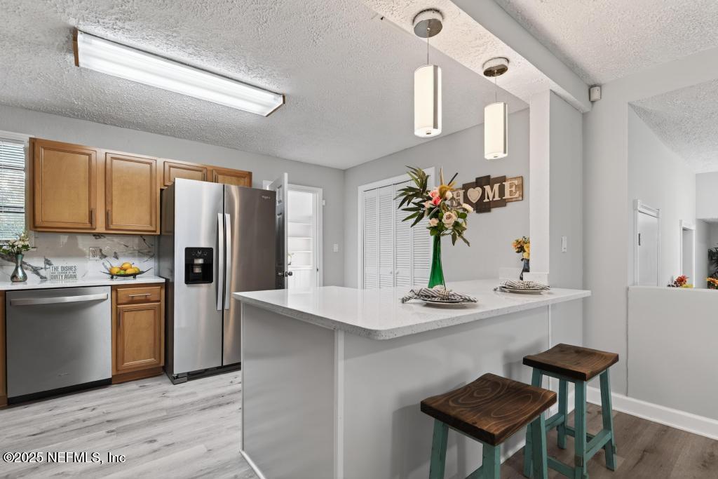 6619 Ector Road Jacksonville, FL 32211 - Photo 20 of 70 a kitchen with stainless steel appliances kitchen island hardwood floor stove sink and refrigerator
