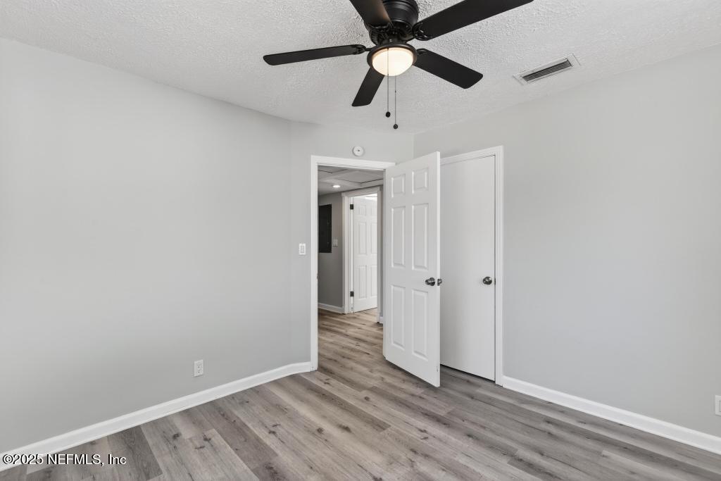 6619 Ector Road Jacksonville, FL 32211 - Photo 56 of 70 an empty room with wooden floor ceiling fan and windows