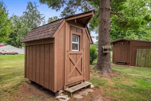 a view of backyard with barbeque grill and wooden fence