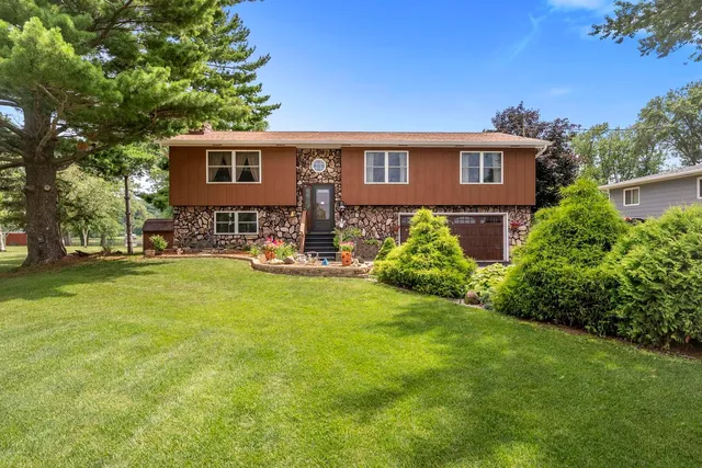 a front view of a house with yard and green space
