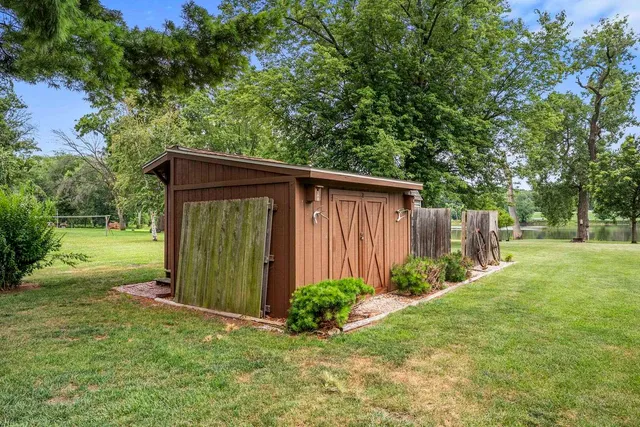 a view of a backyard with large trees and plants