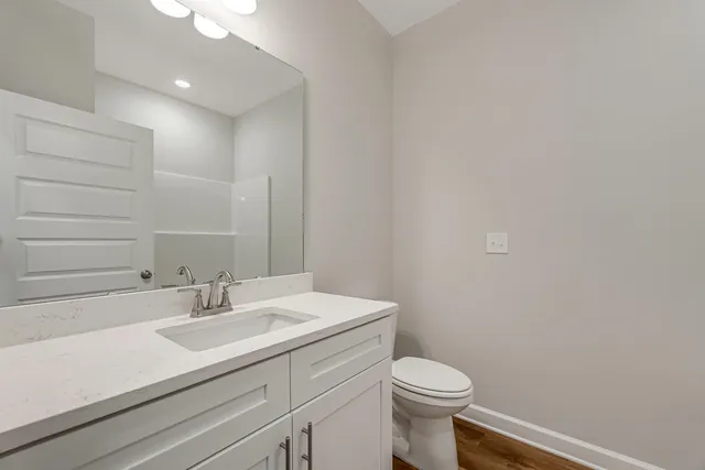 a bathroom with a sink a toilet and mirror