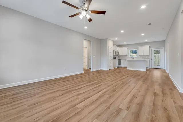 a view of empty room with wooden floor and window