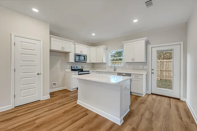 a kitchen with white cabinets and stainless steel appliances