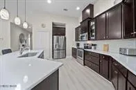 a kitchen with stainless steel appliances kitchen island granite countertop a refrigerator and a sink