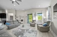 a living room with furniture and a view of kitchen