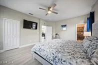 a bedroom with a large bed and a flat tv screen on dresser