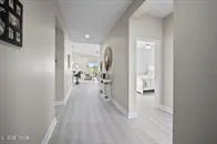 a view of a hallway with wooden floor and a bathroom
