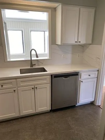 a kitchen with white cabinets and a sink