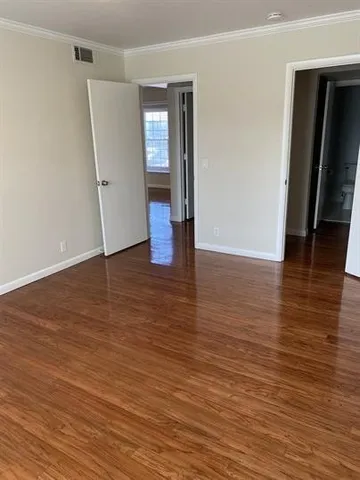 an empty room with wooden floor and closet