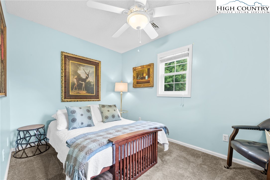17 Elderberry Loop Newland, NC 28657 - Photo 23 of 47 a bedroom with a bed and a chandelier