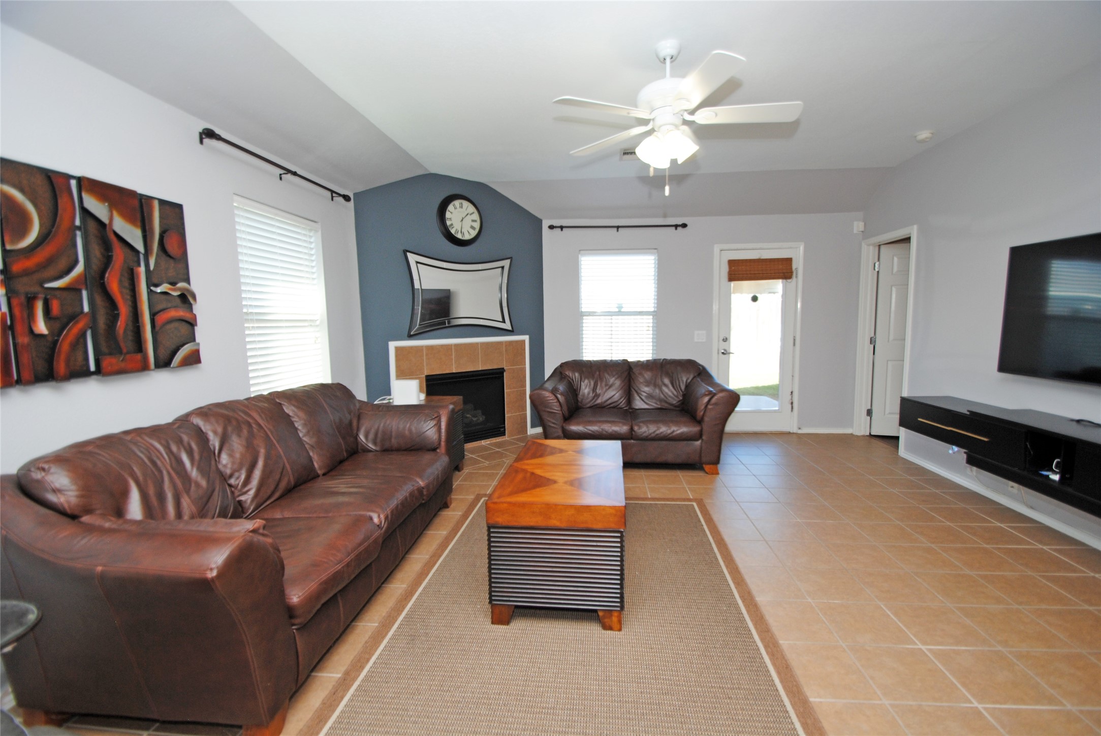 16427 Kettlebrook Lane Houston, TX 77049 - Photo 10 of 27 a living room with furniture a fireplace and a flat screen tv