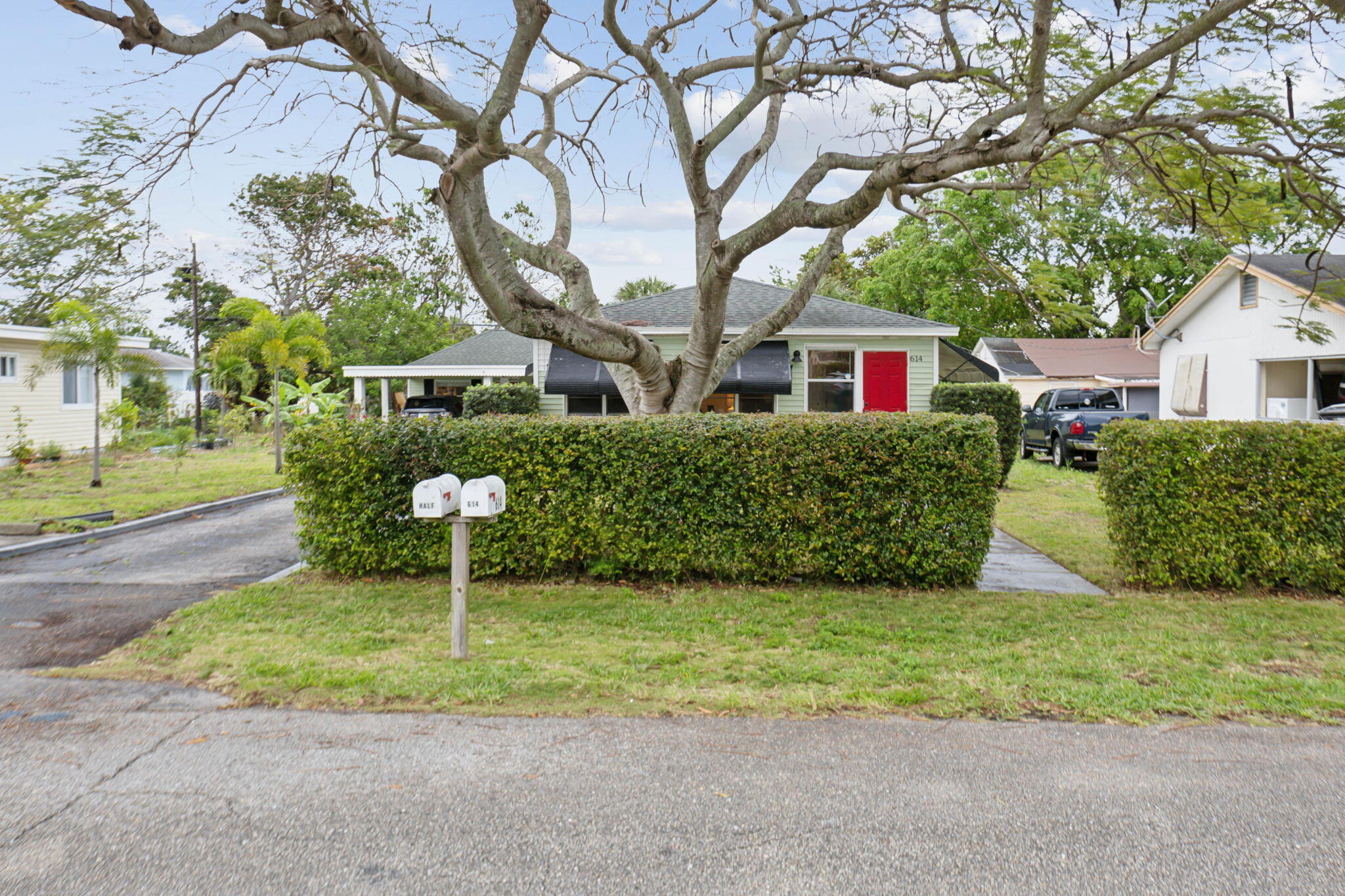 614 North 7th Street, Unit 1/2 Lantana, FL 33462 - Photo 15 of 18 a front view of a house with a yard and garage