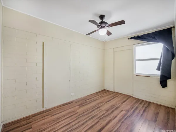 a view of a livingroom with wooden floor and a window