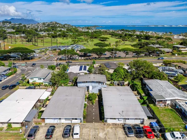 an aerial view of residential houses with outdoor space and ocean view