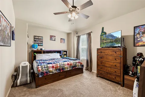 a bedroom with a bed a dresser and a chandelier