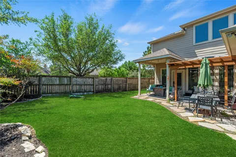 a view of a chair and table in backyard of the house