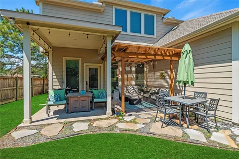 a view of a patio with table and chairs potted plants and floor to ceiling window