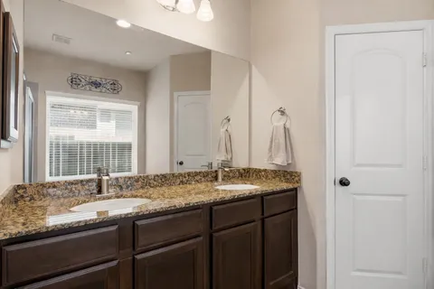 a bathroom with a granite countertop sink and a mirror