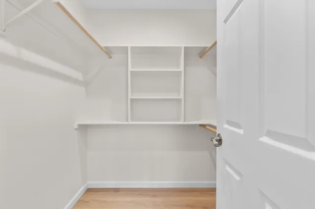a view of walk in closet with empty racks