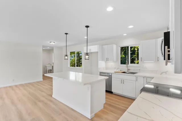 a large kitchen with kitchen island a sink stainless steel appliances and cabinets