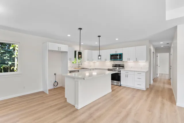 a kitchen with white cabinets and white appliances