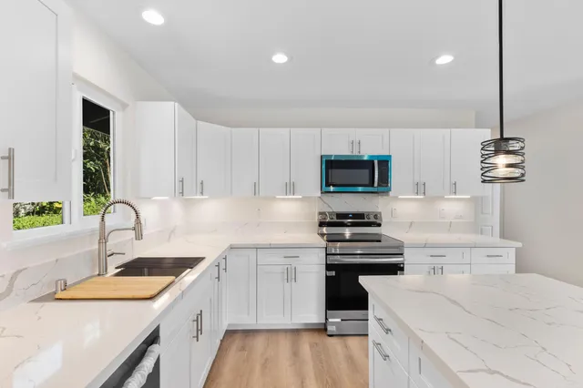 a kitchen with a sink stove top oven and refrigerator