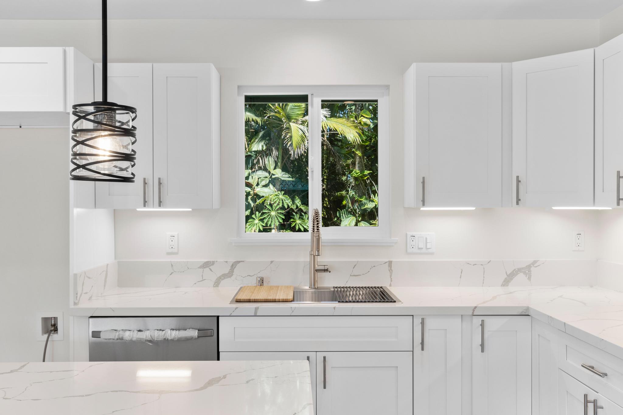 16-2579 Ainaloa Drive Pahoa, HI 96778 - Photo 4 of 30 a kitchen with stainless steel appliances kitchen island a large window cabinets and a sink