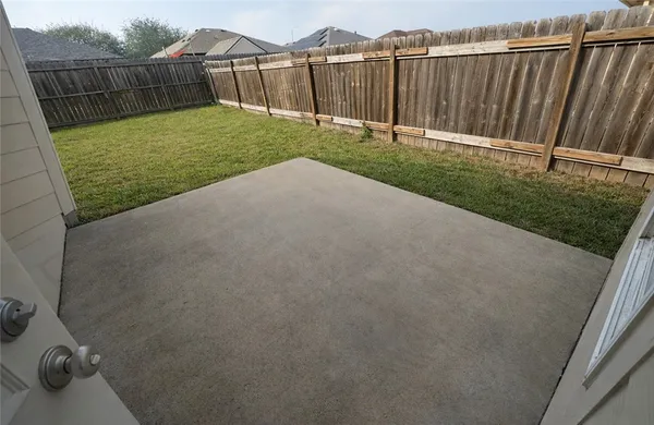 a view of a backyard with wooden fence