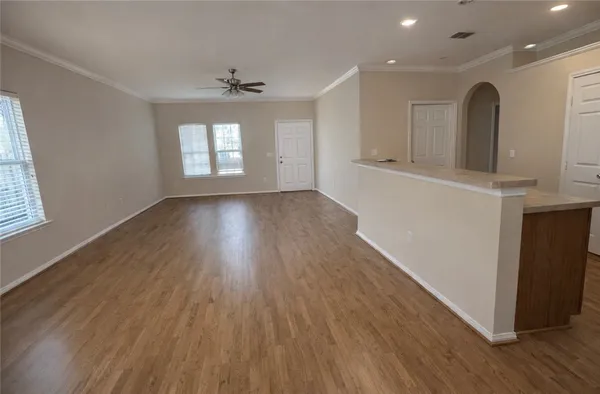 an empty room with wooden floor and windows